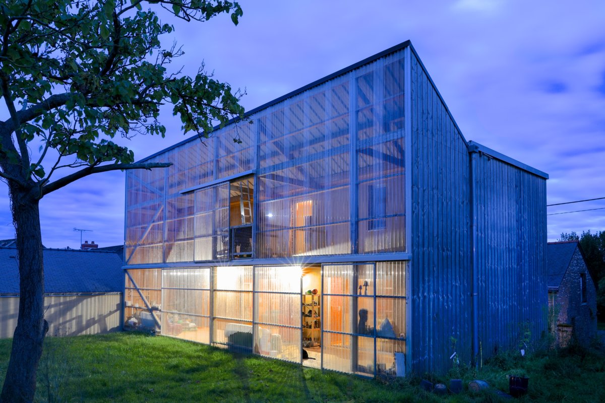 A_ Façade nord de la maison avec son jardin d’hiver derrière une paroi en polycarbonate